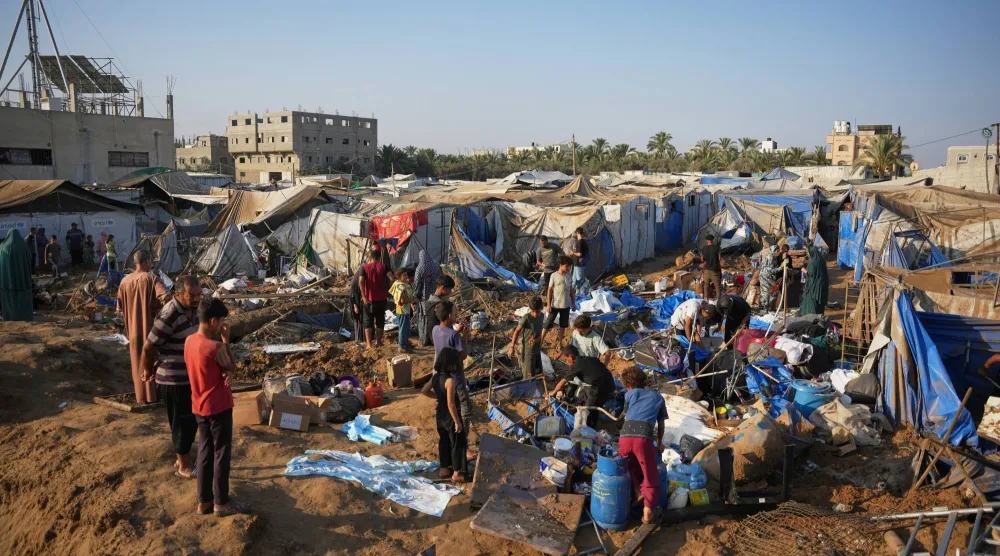 فلسطينيون يتفقّدون موقع غارة جوية إسرائيلية في دير البلح بقطاع غزة يوم 1 أغسطس 2026 (أ.ب)
