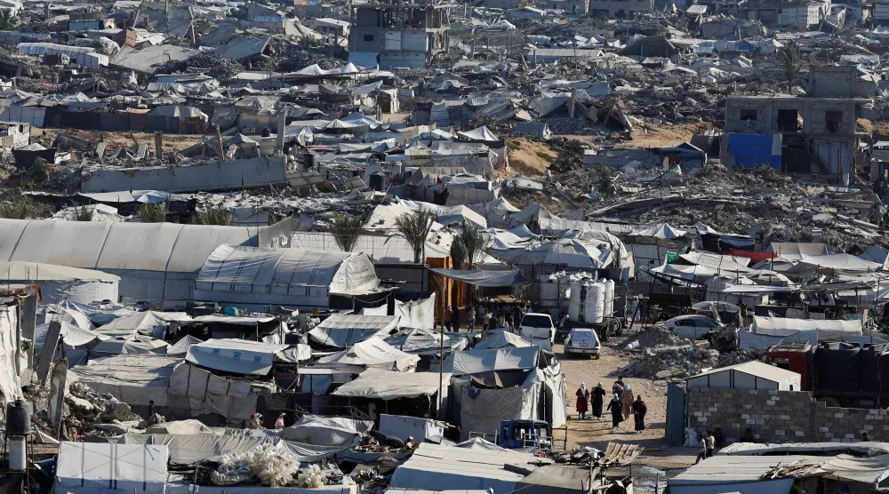 فلسطينيون يسيرون وسط أنقاض مبانٍ سكنية دُمّرت خلال الحرب في مخيم جباليا للاجئين شمال قطاع غزة (رويترز)