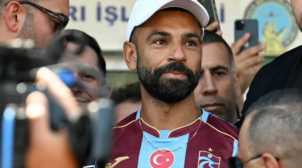 محمد صلاح لدى وصوله إلى مطار أتاتورك في إسطنبول لإتمام انتقاله إلى طرابزون سبور (أ.ف.ب)
