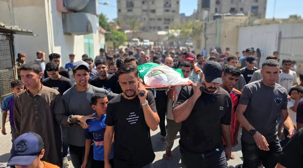 مشيعون يحملون جثمانَ فلسطيني تُوفي يوم الخميس متأثراً بإصابته في ضربة إسرائيلية استهدفت مخيم خان يونس بجنوب قطاع غزة (د.ب.أ)