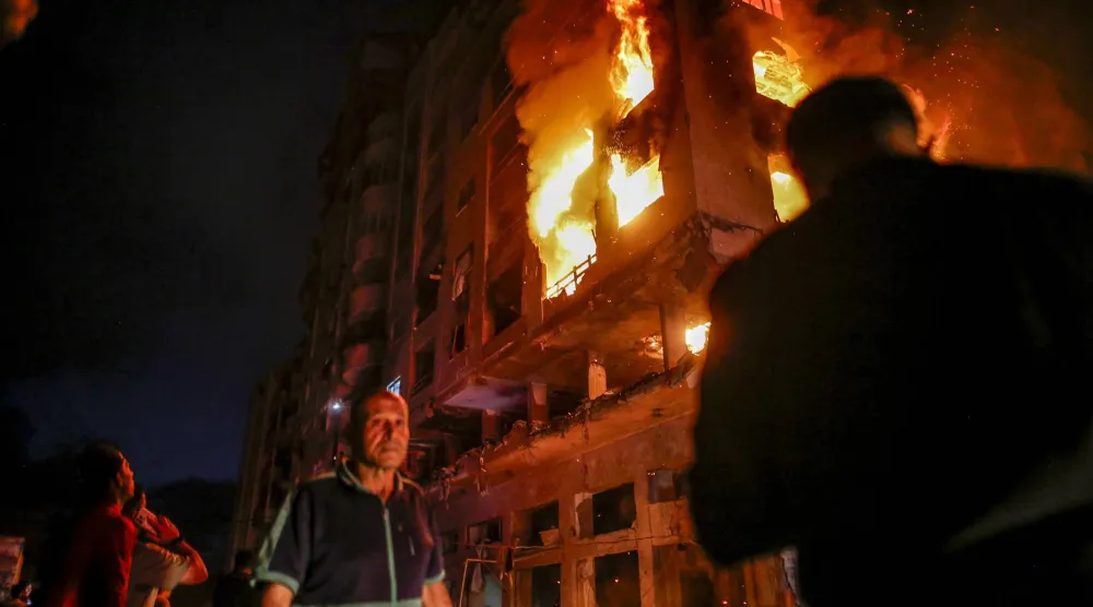 النيران مندلعة بمبنى سكني قصفته إسرائيل خلال استهداف القائد العسكري لـ«حماس» عز الدين الحداد بحي الرمال في مدينة غزة ليل 15 مايو 2026 (إ.ب.أ)