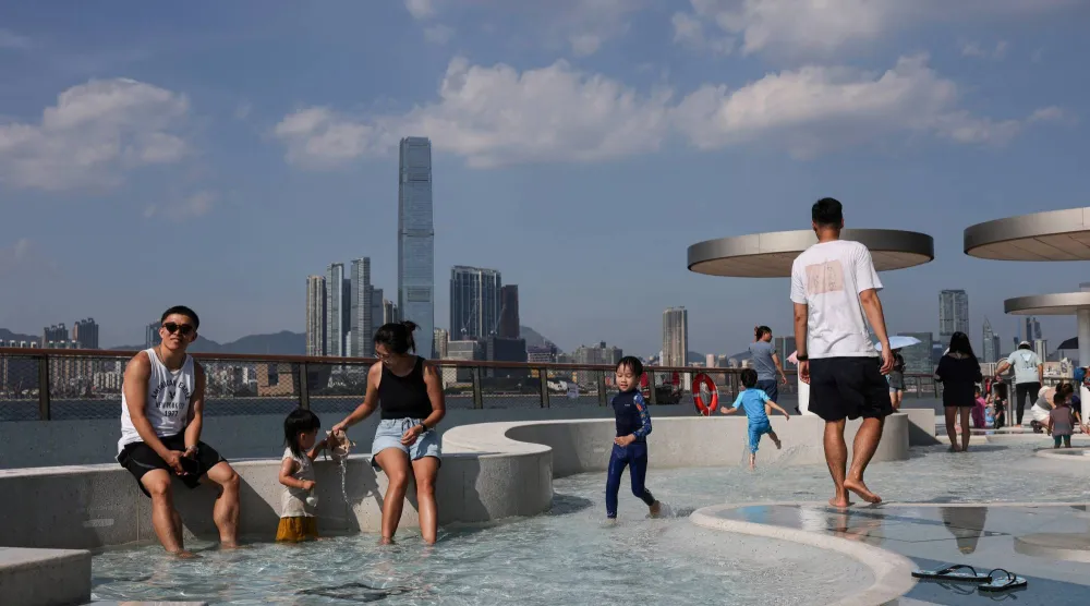 Parents and children cool off in a shallow wading pool at a public park amid extreme heat brought by Typhoon Dolphin, as the city recorded its hottest day in 142 years, in Hong Kong, China, August 9, 2026. REUTERS/Tyrone Siu
