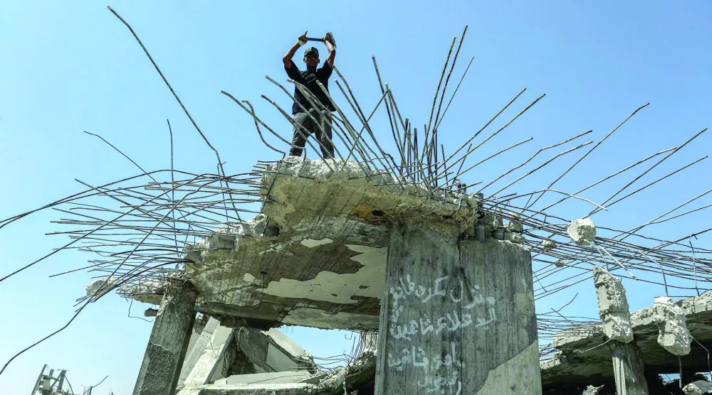 فلسطيني يستخرج الحديد من أنقاض المنازل التي دمَّرها الجيش الإسرائيلي خلال الحرب في خان يونس (د.ب.أ)
