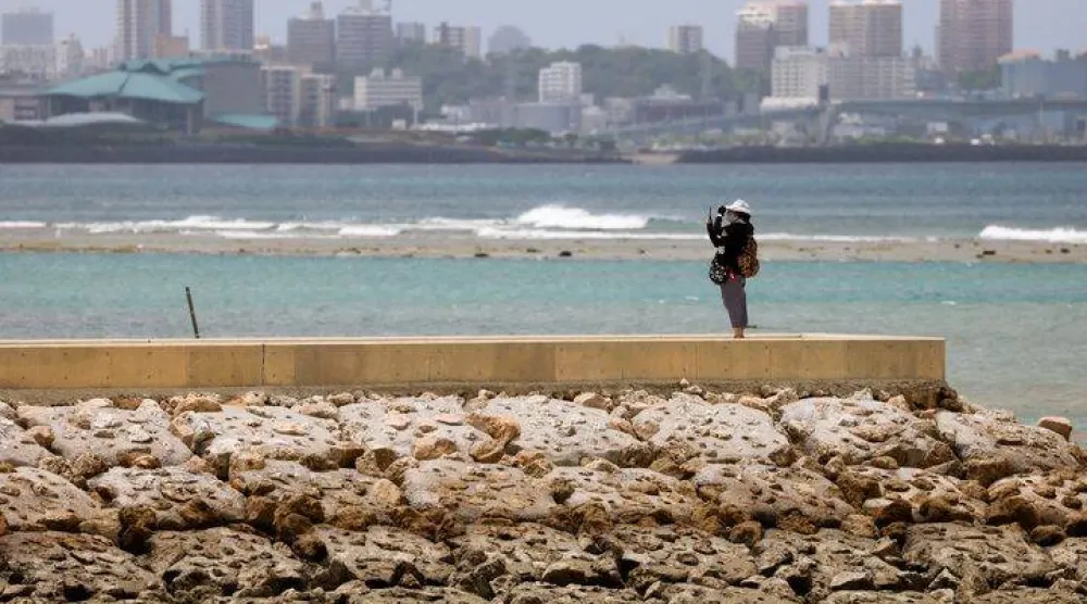 زائر ينظر إلى البحر مع اقتراب إعصار هايكوي من المنطقة على شاطئ سانسيت في تشاتان بمحافظة أوكيناوا باليابان (أرشيفية-رويترز)