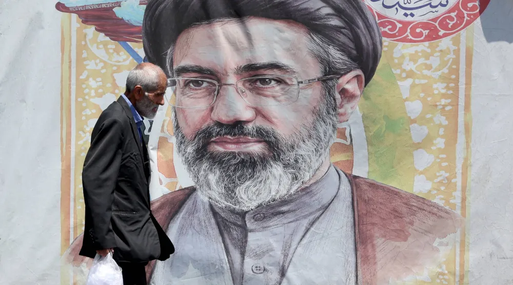 إيراني يمر أمام صورة للمرشد مجتبى خامنئي في طهران غداة توقيع اتفاق إنهاء الحرب مع الولايات المتحدة (إ.ب.أ)