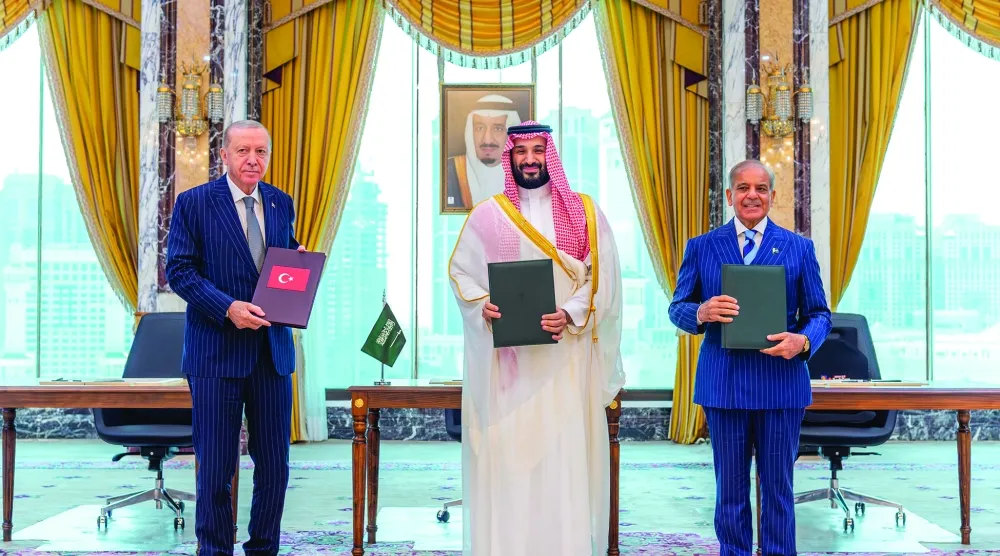   امیر محمد بن سلمان، رئیس‌جمهوری اردوغان و نخست‌وزیر شهباز شریف را پس از امضای «توافق‌نامه مکه برای دفاع مشترک» در میان گرفته است (واس)