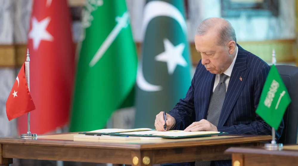 الرئيس التركي رجب طيب إردوغان خلال توقيعه «اتفاقية مكة للدفاع المشترك» الجمعة (واس)