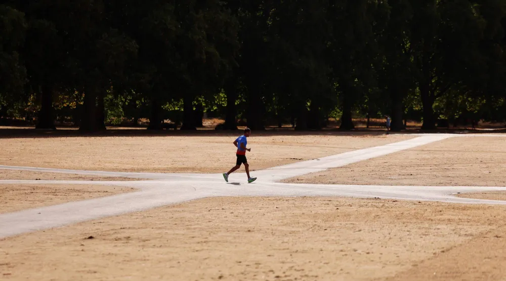 A man runs across the parched park lands of Hyde Park in central London, Britain, 11 August 2026. (EPA)