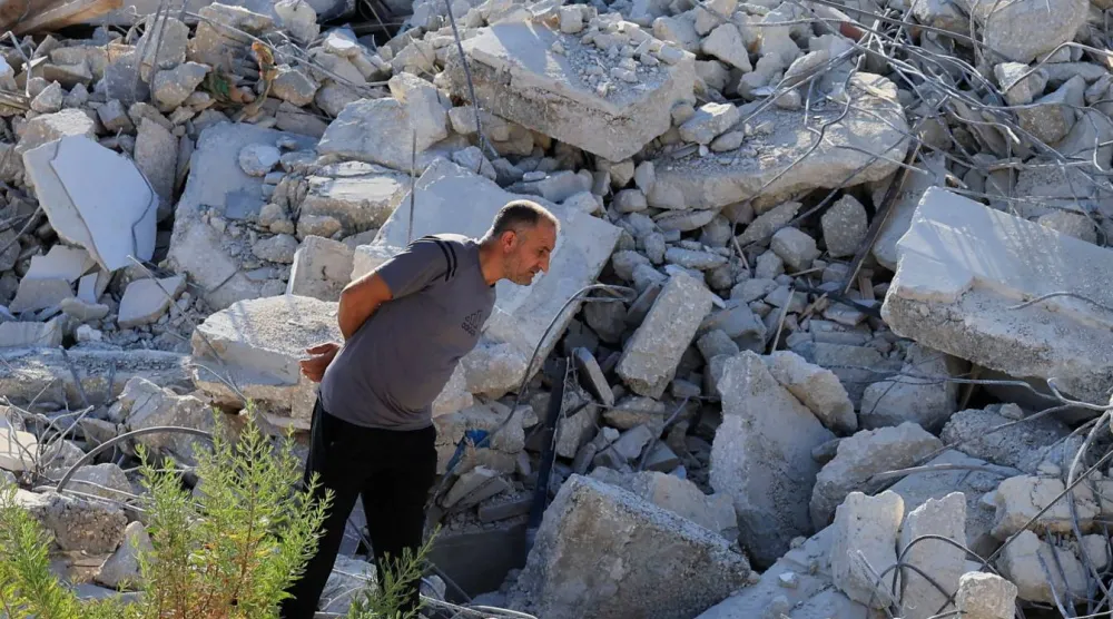 فلسطيني يتفقد الأضرار بعد أن هدمت آليات إسرائيلية مبنى فلسطينياً قرب بيت لحم في الضفة الغربية المحتلة (رويترز)