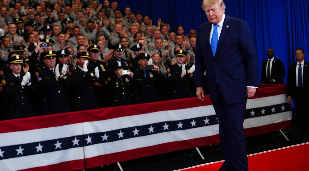 Police officers applaud as President Donald Trump arrives to speak at the David Mack Center for Training and Intelligence, Friday, Aug. 14, 2026, in Garden City, N.Y. (AP Photo/Julia Demaree Nikhinson)