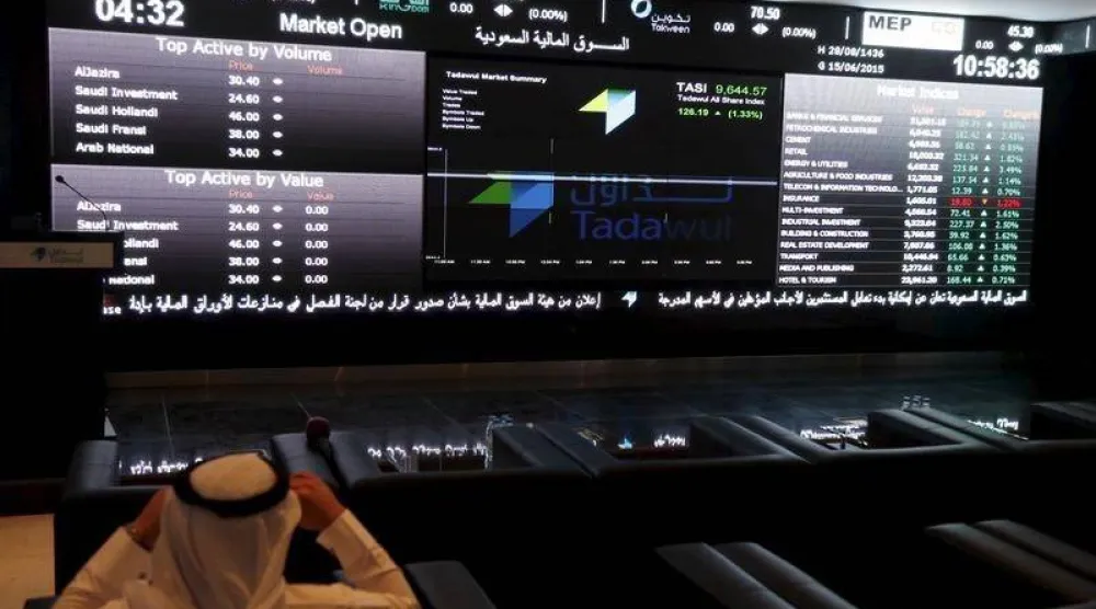 مستثمر يتابع شاشات التداول في «السوق السعودية» (رويترز)