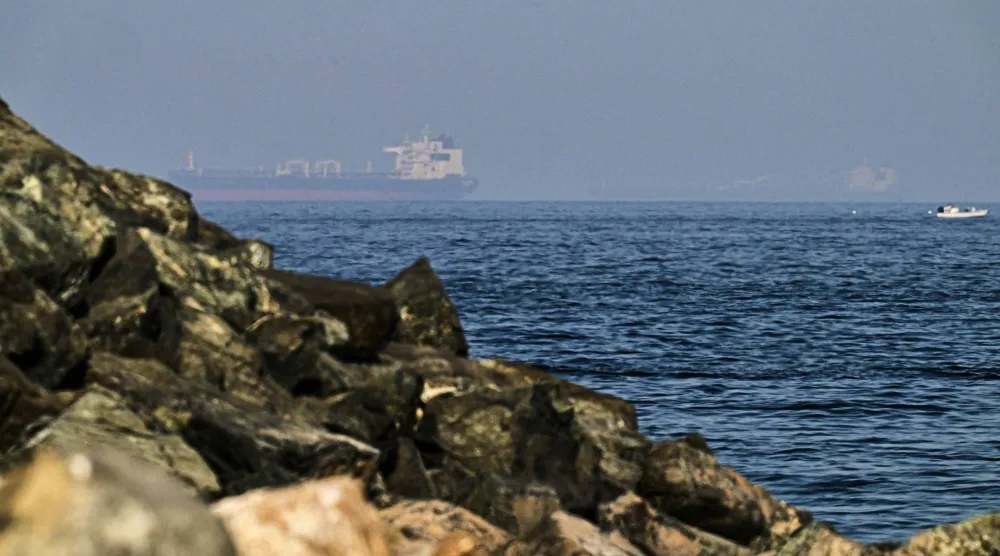 FILE - Cargo ships are seen at sea in the Gulf of Oman near the Strait of Hormuz, from a rocky shoreline near Khor Fakkan, United Arab Emirates, May 1, 2026. (AP Photo/Fatima Shbair, File)