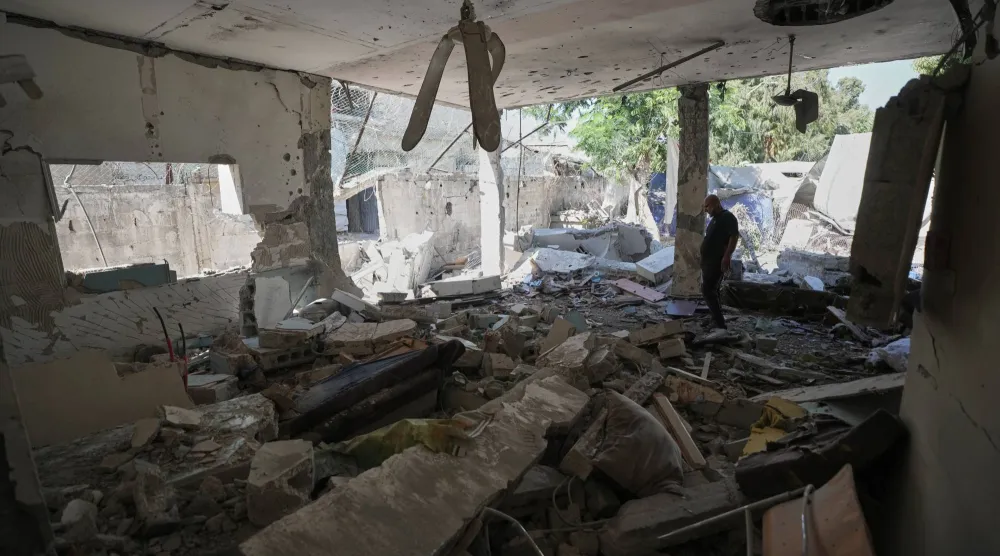 فلسطينيون يتفقدون الأضرار في مركز للشرطة بعد قصف إسرائيلي بمدينة غزة يوم الأربعاء (أ.ب)