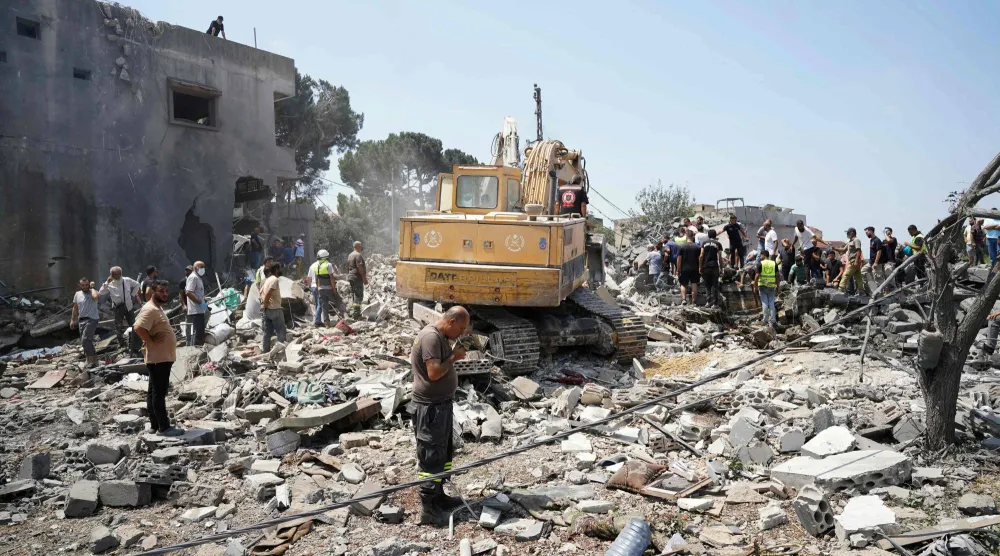 آليات وفرق إسعاف وسكان يفتشون موقع غارة جوية إسرائيلية استهدفت حياً في قرية دير الزهراني جنوب لبنان - 15 أغسطس 2026 (أ.ف.ب)