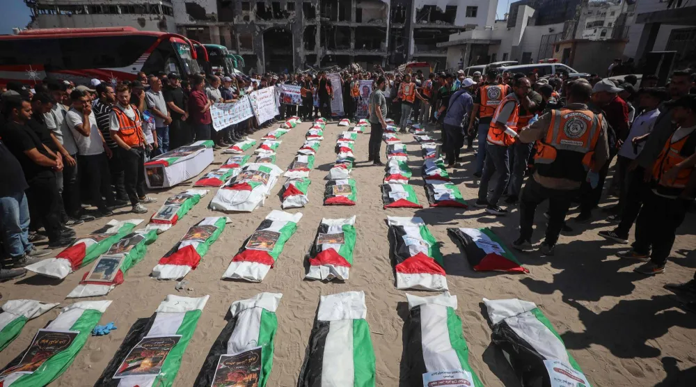 مشيعون يلتفون حول بقايا فلسطينيين قتلوا في ضربات خلال حرب غزة قبيل دفنهم بمدينة غزة يوم الخميس (أ.ف.ب)