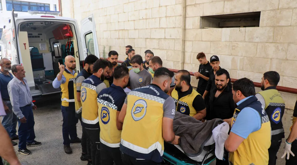 يحمل أعضاء «الخوذ البيضاء» (الدفاع المدني السوي) جثمان محمد غمرة المتطوع السابق قبل دفنه في قرية الحفة بمحافظة اللاذقية يوم الاثنين الماضي (أ.ب)