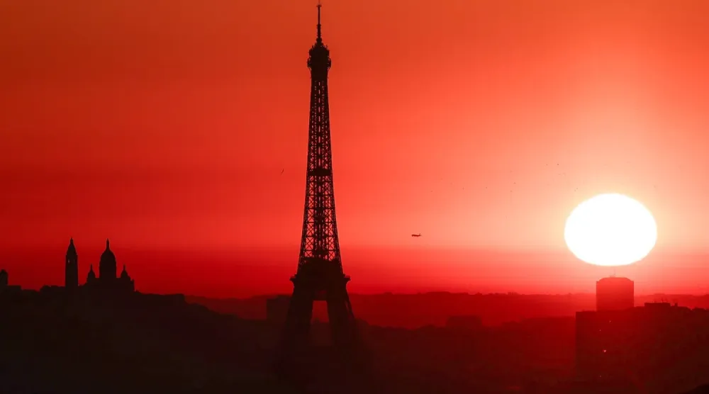 Güneş, Paris’teki «Eyfel Kulesi’nin» yanında doğuyor; şehir, sıcaklıkların yükselmesi nedeniyle en yüksek alarm seviyesinde (AFP)