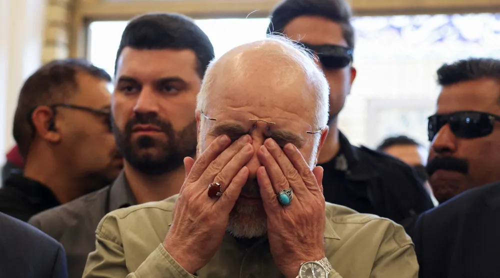 رئيس البرلمان الإيراني محمد باقر قاليباف باكياً في النجف العراقية يوم الجمعة عند قبر أبو مهدي المهندس الذي قُتل إلى جانب قاسم سليماني في غارة أميركية في يناير 2020 (رويترز)