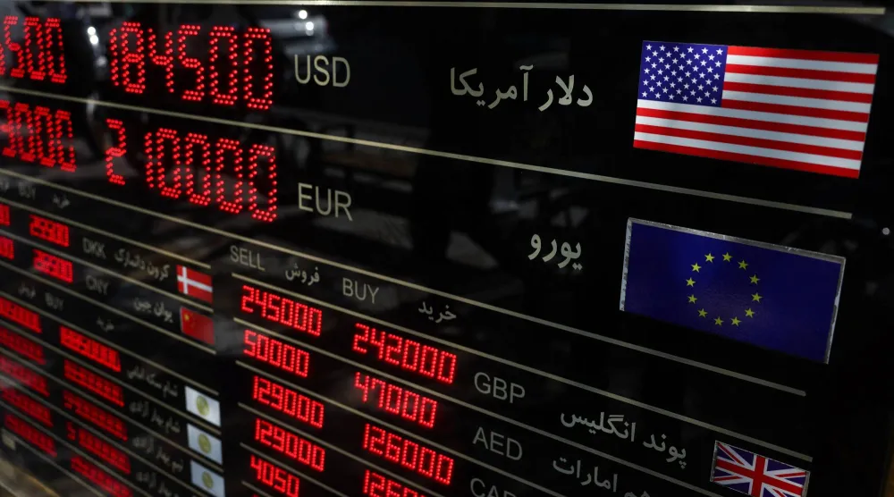 شاشة تعرض معلومات عن أسعار صرف العملات في السوق الكبير بطهران (رويترز)