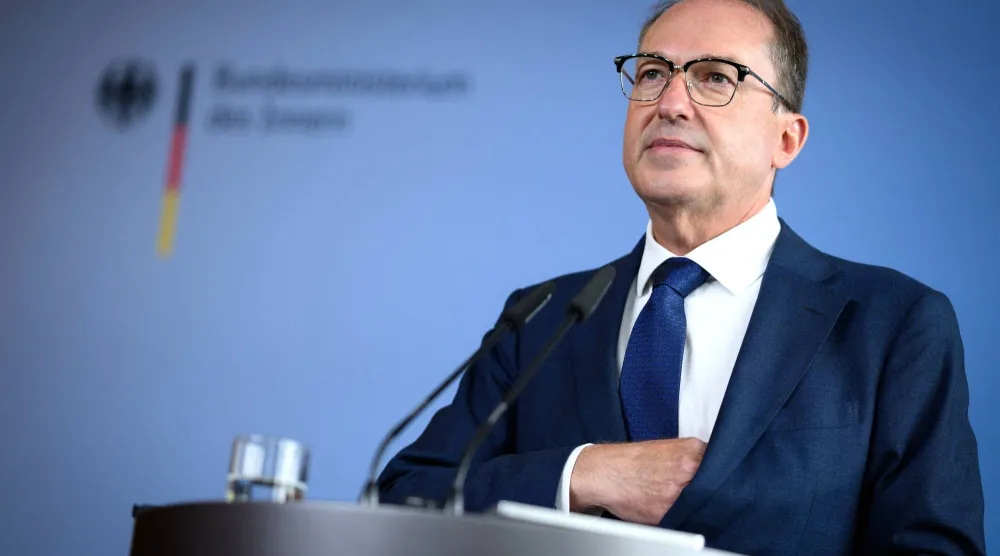 وزير الداخلية الألماني ألكسندر دوبرينت يعلن عن العثور على أسلحة مخبأة في غابة في برلين العام الماضي (د.ب.أ)