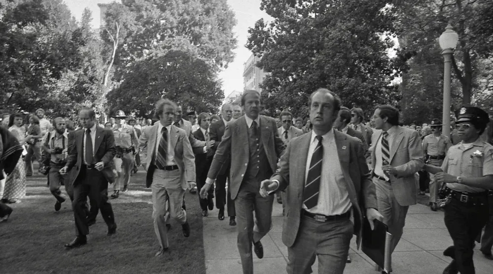 فورد أثناء إجلائه بواسطة الخدمة السرية الأميركية من موقع محاولة اغتياله عام 1975 في ساكرامنتو بكاليفورنيا (ويكيبيديا)