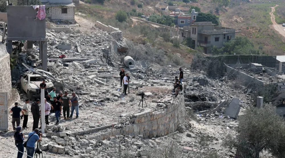 People inspect a damaged building after an Israeli airstrike on the village of Ansar, southern Lebanon, 15 August 2026. (EPA)