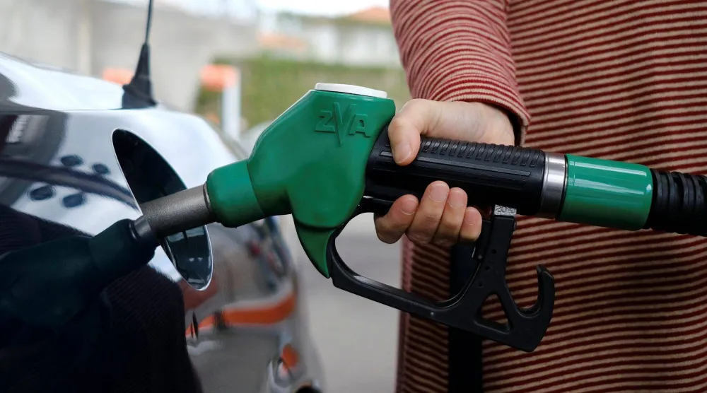 سيدة تزود سيارتها بالوقود بإحدى المحطات في لشبونة (رويترز)