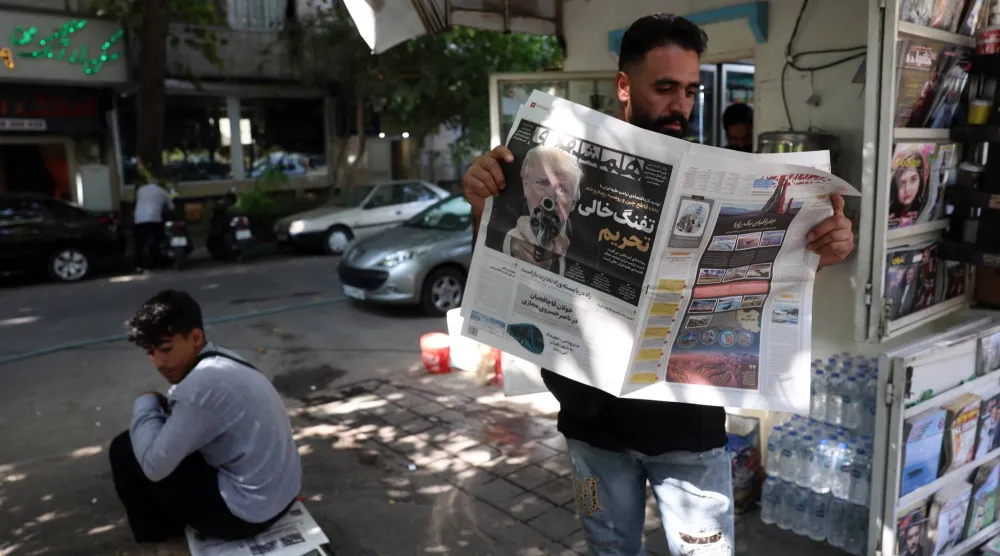 رجل إيراني يقرأ نسخة من صحيفة همشهري في إيران (إ.ب.أ)