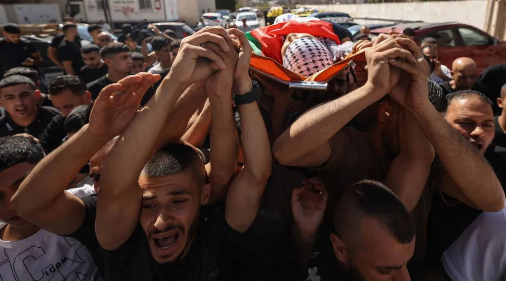 Mourners carry the body of Palestinian Islam Ajouri, 14, at Rafidia Hospital in Nablus in the Israeli-occupied West Bank, on August 23, 2026. (Photo by JAAFAR ASHTIYEH / AFP)