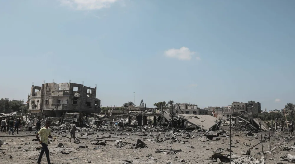 فلسطينيون يتفقدون الدمار عقب غارة على مخيم المغازي بوسط قطاع غزة (د.ب.أ)
