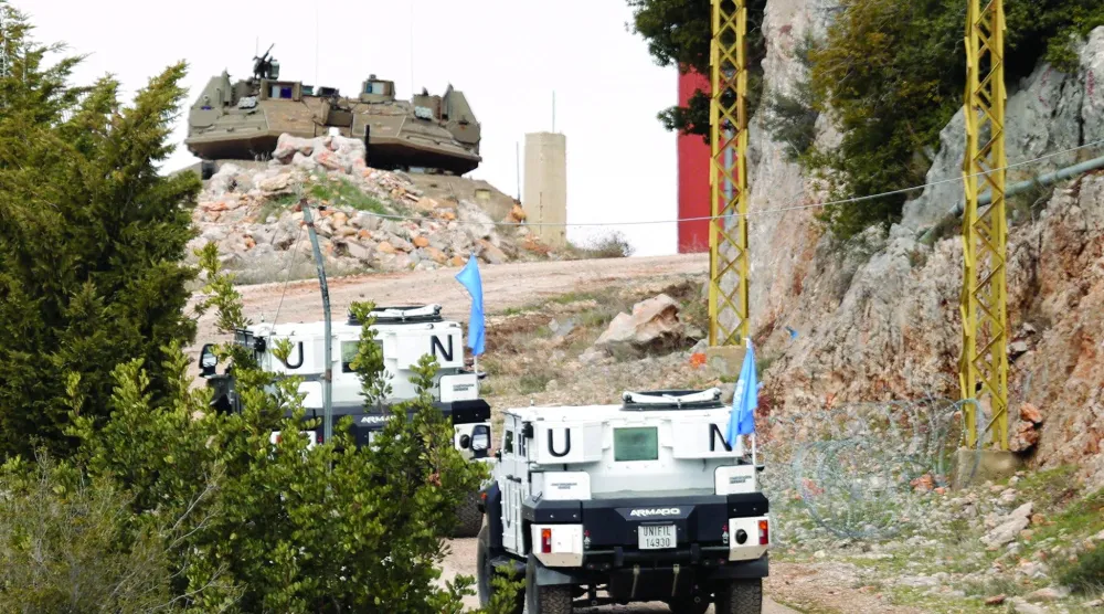 آليات تابعة لقوات «يونيفيل» تتجه نحو منطقة كفرشوبا جنوب لبنان وتبدو فوقها دبابة إسرائيلية (أرشيفية - أ.ف.ب)