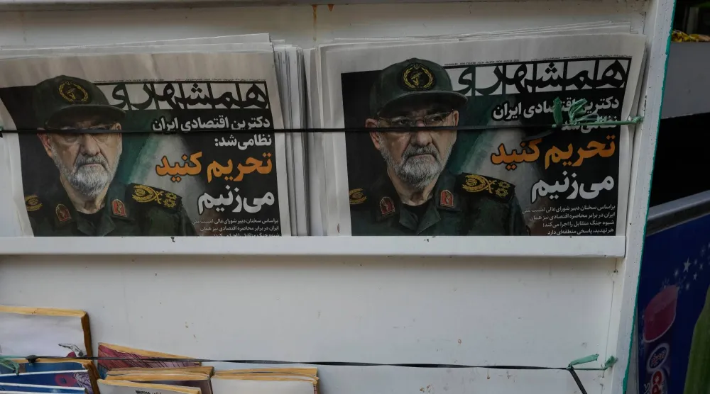 صحيفة «همشهري» الإيرانية معروضة في كشك بوسط طهران تحت عنوان «العقيدة الاقتصادية الإيرانية أصبحت عسكرية» وصورة أمين المجلس الأعلى للأمن القومي محسن رضائي... الاثنين 24 أغسطس 2026 (أ.ب)