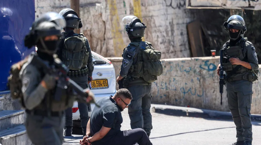 القوات الإسرائيلية تعتقل فلسطينياً خلال مداهمة مركز تابع لـ«الأونروا» جنوب رام الله بالضفة الغربية يوم الثلاثاء (أ.ف.ب)