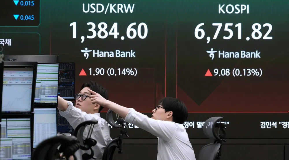 متداولو العملات يراقبون شاشات تعرض مؤشر «كوسبي» وسعر صرف العملات الأجنبية بين الدولار الأميركي والوون الكوري الجنوبي في غرفة تداول العملات الأجنبية بمقر بنك هانا في سيول (أ.ب)