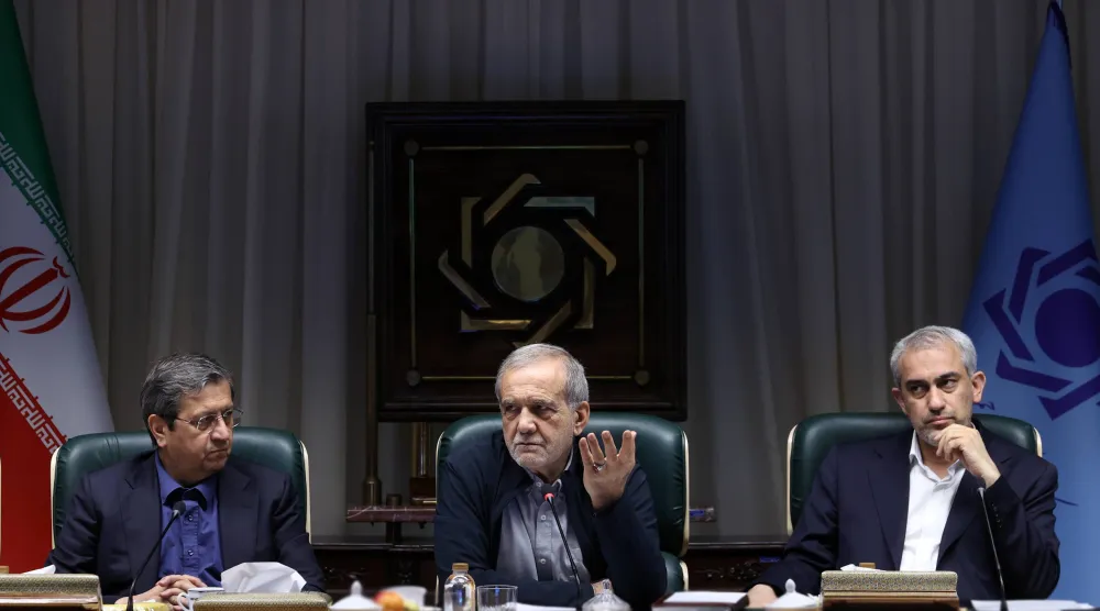 بزشكيان يتوسط وزير الاقتصاد علي مدني زاده ومحافظ البنك المركزي عبد الناصر همتي خلال اجتماع مالي اليوم (الرئاسة الإيرانية)