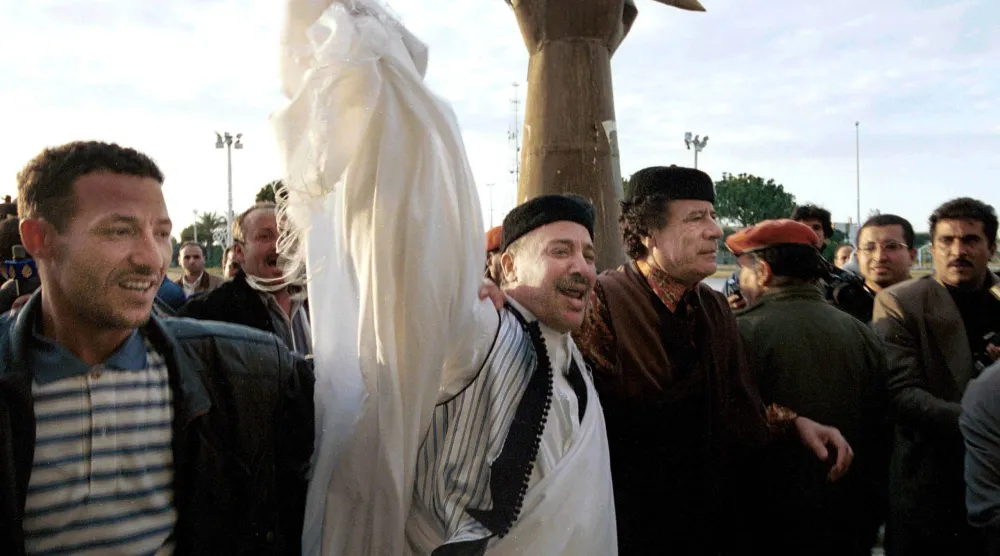 صورة تجمع الرئيس الليبي الراحل معمر القذافي، وإلى جواره (الثاني من اليسار) الأمين خليفة فحيمة، وذلك فور وصول الأخير إلى العاصمة طرابلس غداة تبرئته قطعيّاً من قضية تفجير الطائرة (طرابلس 1 فبراير 2001) (غيتي)
