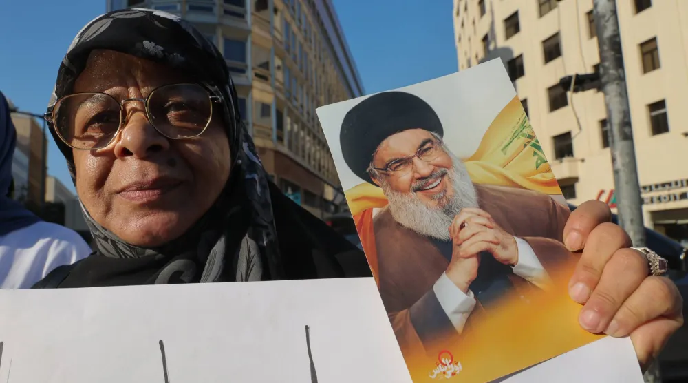 مناصرة لـ«حزب الله» تحمل صورة أمينه العام السابق حسن نصر الله خلال حراك في وسط بيروت ضد المفاوضات اللبنانية مع إسرائيل برعاية أميركية (إ.ب.أ)