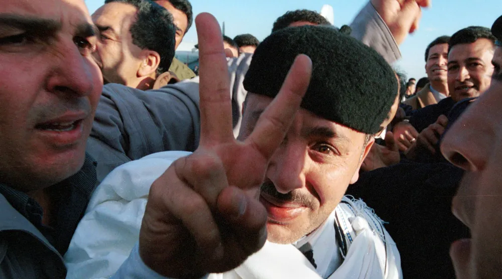 الأمين خليفة فحيمة مُلوّحاً بيده بعد يوم واحد من تبرئته في محاكمة تفجير لوكربي (غيتي)