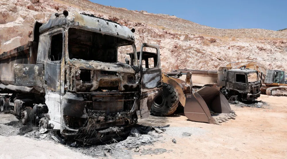 معدات ثقيلة محترقة في محجر فلسطيني بعد هجمات شنّها مستوطنون قرب رام الله بالضفة الغربية يوم الاثنين (رويترز)