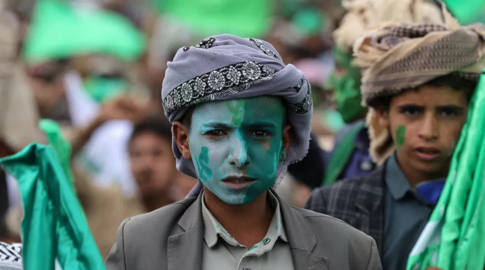 صبي ملطخ وجهه بالألوان يشارك في حشد للحوثيين بصنعاء (رويترز)