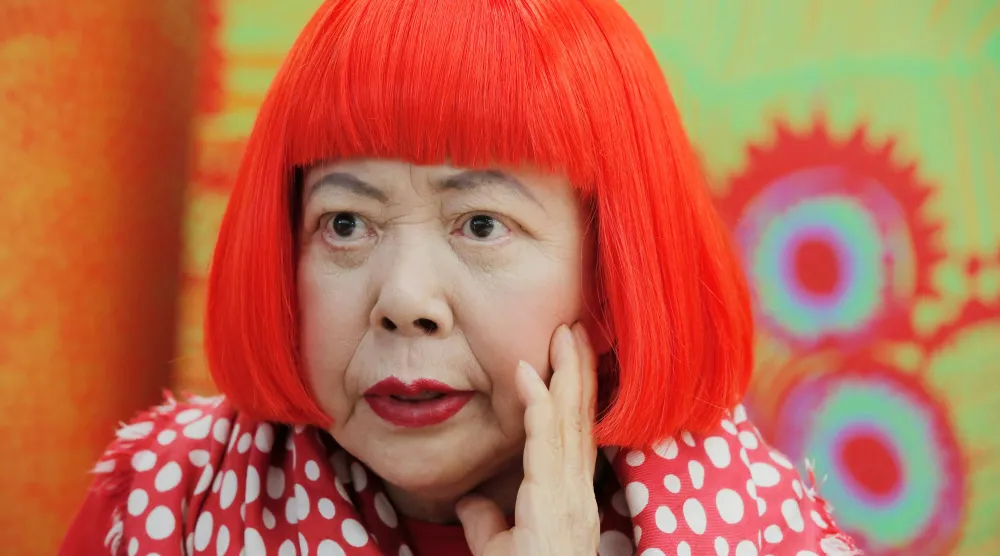  Japanese avant-garde artist Yayoi Kusama, wearing a bright red wig and a Louis Vuitton polka dot scarf, speaks during an interview at her studio in Tokyo, on Aug. 1, 2012. (AP) 