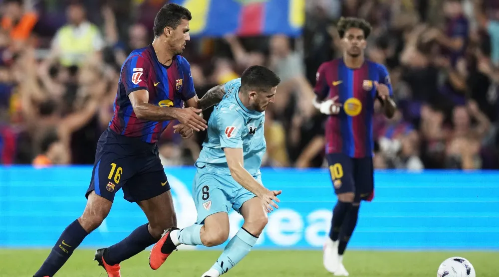 لاعب برشلونة رودري (يسار) يتنافس على الكرة مع أويهان سانسيت لاعب أتلتيك بلباو (إ.ب.أ)