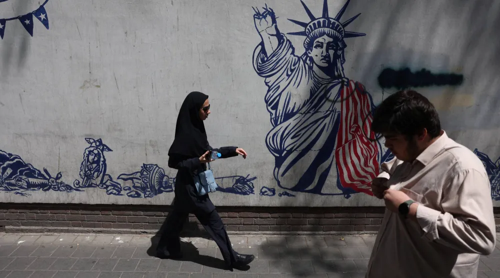 إيرانيون يمرون قرب جدارية مناهضة للولايات المتحدة في طهران يوم 15 يوليو 2026 (رويترز)