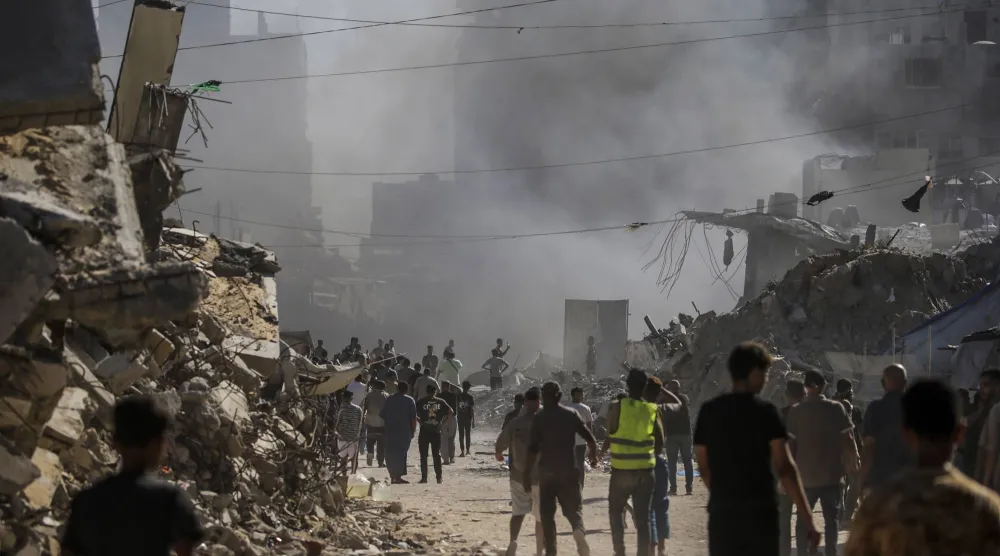 فلسطينيون يتفقدون الأضرار الناجمة عن غارة جوية إسرائيلية على حي الشيخ رضوان شمال غربي مدينة غزة (إ.ب.أ)