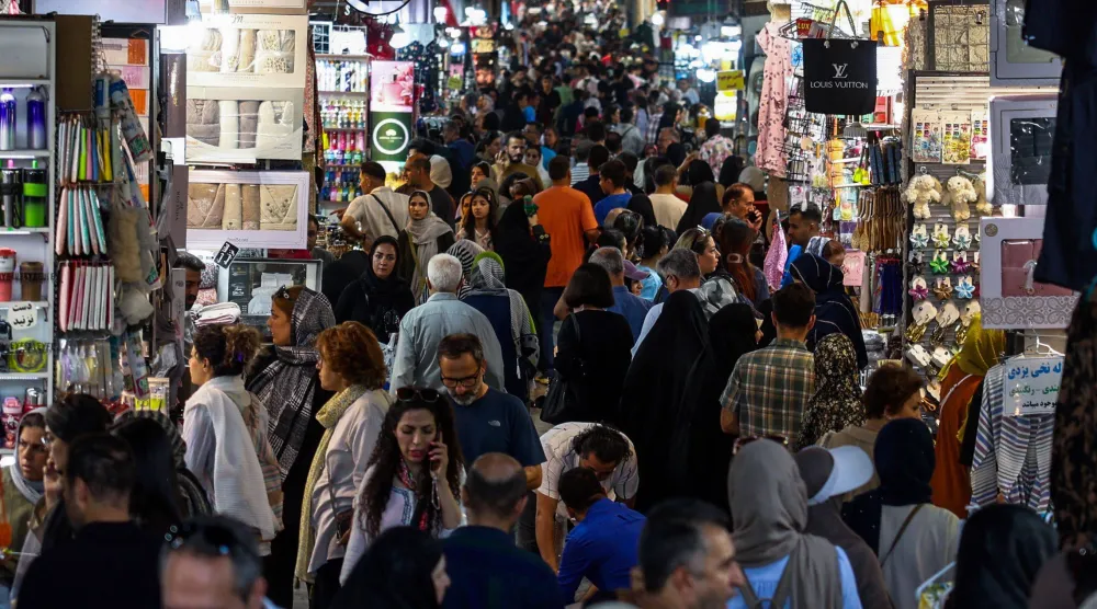 متسوقون يتجولون بين المحال في «البازار الكبير» بطهران يوم 24 أغسطس وسط تدهور الوضع الاقتصادي بسبب العقوبات (أ.ف.ب)