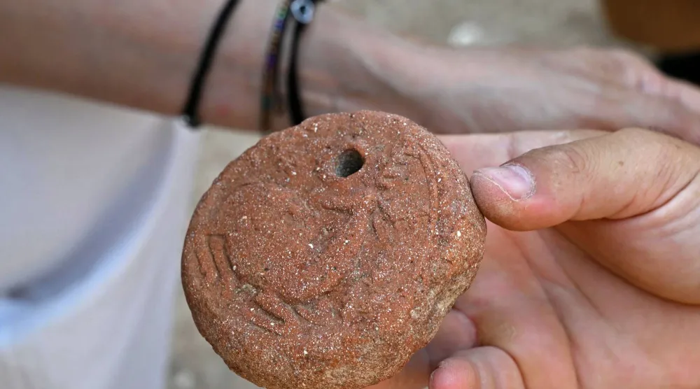 An archaeologist displays an artifact found from an archaeological site in the northern coastal Lebanese town of Batroun on August 14, 2026. (AFP) 