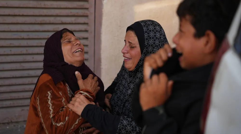 فلسطينيات يبكين بجوار جثمان حمودة العطار الذي قتله الجيش الإسرائيلي في وسط قطاع غزة (أ.ب)