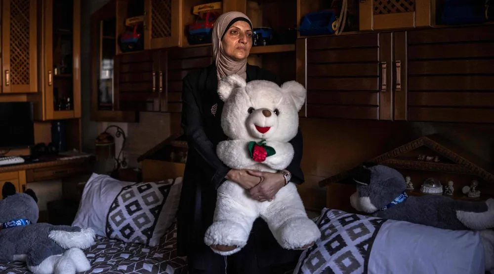الأم الفلسطينية خلود محمود والدة محمود ذات الخمسة عشر عاماً عند مقتله على يد القوات الإسرائيلية عند عودته من المدرسة تحمل دُمية خلال التصوير في الضفة الغربية (أ.ف.ب)