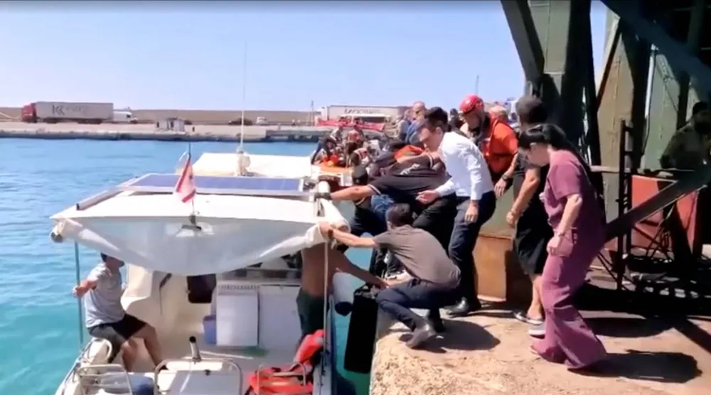 قوارب الإنقاذ تنقل الركاب إلى الشاطئ من قارب انقلب بشمال قبرص في لقطة مأخوذة من مقطع فيديو (رويترز)