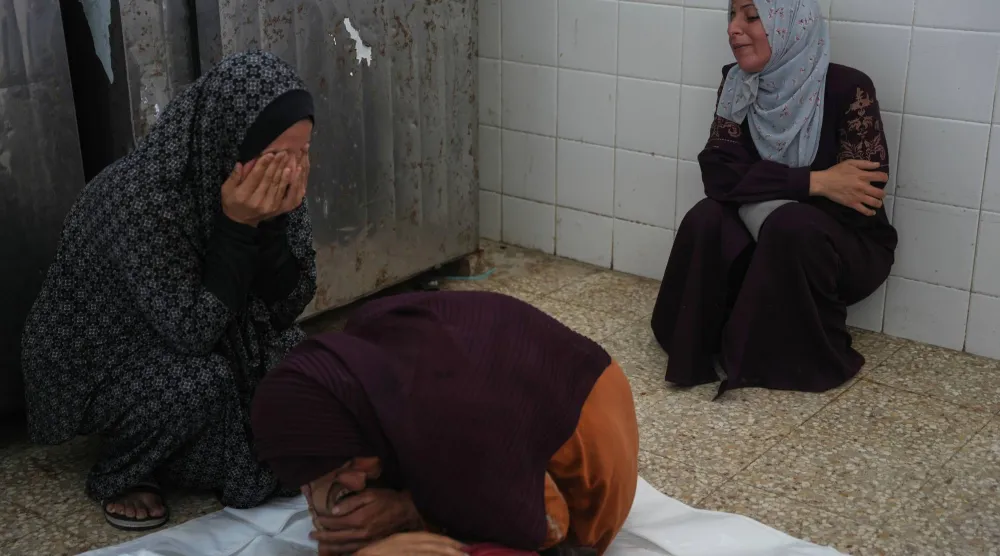 فلسطينيات يبكين على جثمان أحد أقاربهم خلال جنازته في مستشفى الأقصى بدير البلح وسط قطاع غزة (أ.ب)